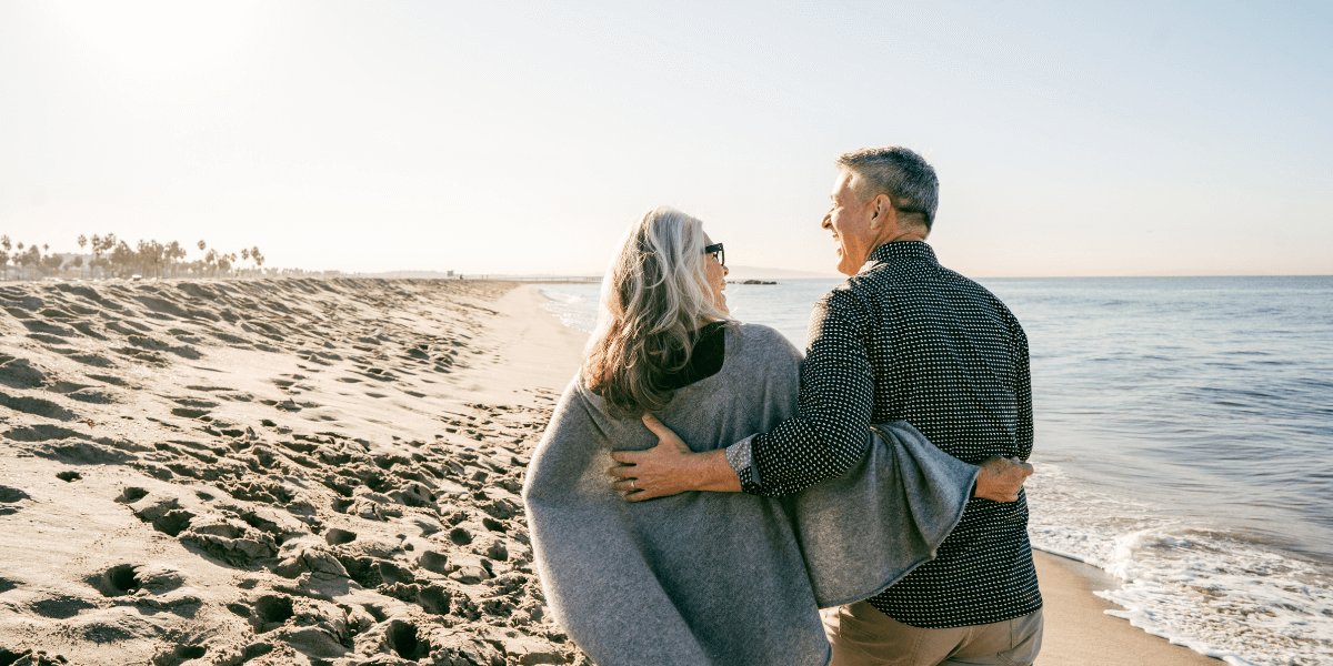 Two people walking on beach | Individual Health Insurance