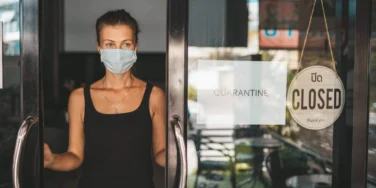 Store Owner in medical mask closed restaurant for quarantine