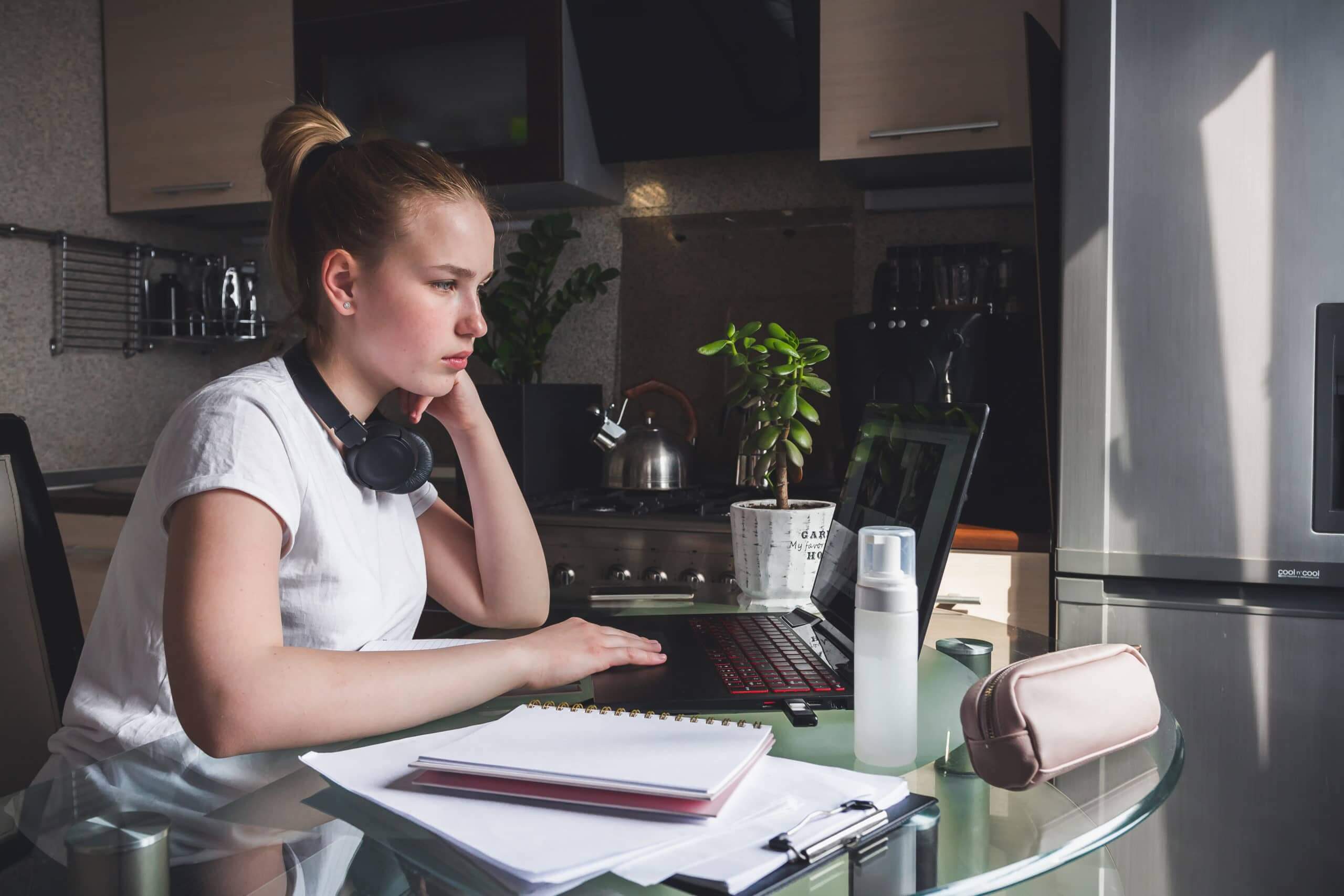 Coronavirus. Quarantine. Online training, remote work, office at home in the kitchen. Remote work, training, education. The girl is studying, working remotely. Coronavirus pandemic in the world.
