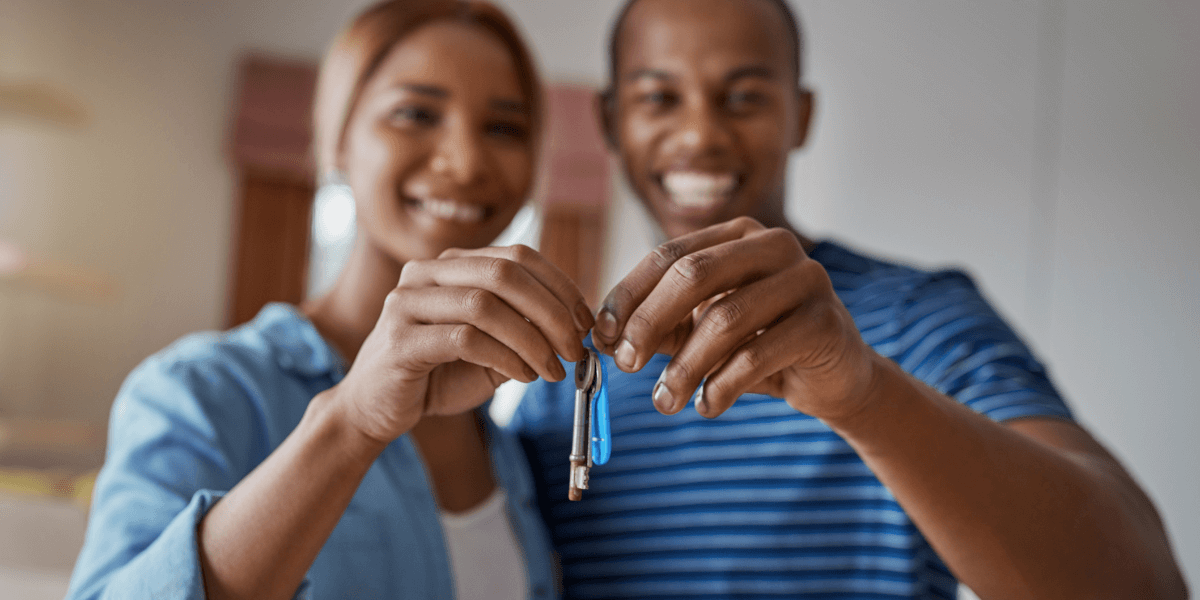Two people holding the keys to their new home